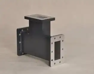 What are the advantages and disadvantages of using an H-Plane Tee in a waveguide-based communication system?